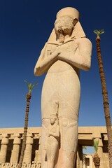 Temple of Karnak, Luxor City, Egypt, Africa. Rameses II statue with Queen Nefertiti in front of him.
