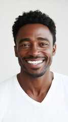 Obraz premium Smiling african male adult in white shirt against light background