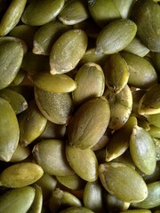 A close-up of fresh, green pumpkin seeds showcasing their smooth texture and natural detail. Perfect for themes of healthy eating, nutrition, and plant-based ingredients.