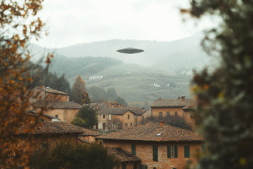 Obraz premium UFO hovers silently above a picturesque mountain village surrounded by nature