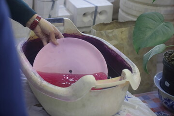 Checking a faience plate blank for cracks after the initial firing, porcelain production, Gzhel,...