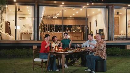 Happy family holding glowed sparkler in holiday celebration party at night. Lovely member enjoy playing spark toy together. Outdoor activity to cross generation gap strengthen family bond. Divergence.