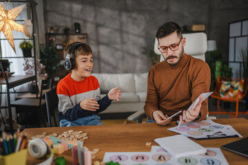 Fototapeta premium young boy practice letters with male speech therapist at home