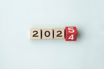 Wooden cube block flipping from 2024 to 2025. Text 2025 written on wooden cube blocks. Preparation...