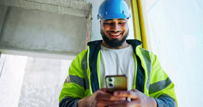 Man, engineer and typing on mobile for construction, planning project or check building schedule. Happy architect, site and phone for communication, text and infrastructure maintenance in low angle