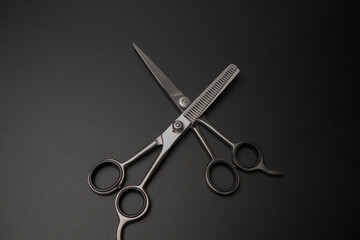 Professional haircutting and thinning scissors set against a black background.