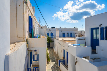 Narrow alley with typical traditional Greek houses on street of Chora village, Folegandros island,...