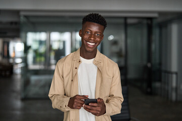Portrait of happy African business man employee or student using smartphone at work. Smiling young...