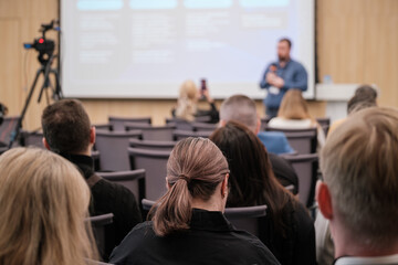 Audience attentively listening to speaker during business presentation at conference. Focus on interaction, professional growth, and learning environment.
