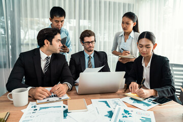 Diverse group of business analyst team analyzing financial data report paper on office table. Chart...