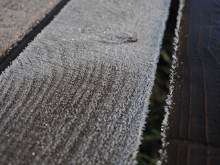 Close-up of the boards, one of which is covered with dark oil. Protecting wood from external conditions