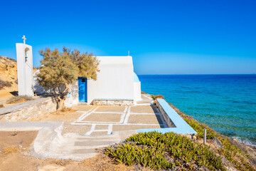 Small white Greek chapel on sea cliff at Amites beach, Naxos island, Cyclades, Greece