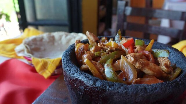 Traditional Mexican food Chicken Fajitas in Molcajete