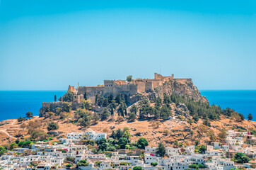 Obraz premium The village of Lindos with whitewashed houses and the iconic Acropolis on top of the hill. In Rhodos Island, Dodecanese, Greece.