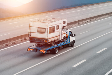 Tow Truck Transporting a Vintage Camper for Emergency Roadside Assistance