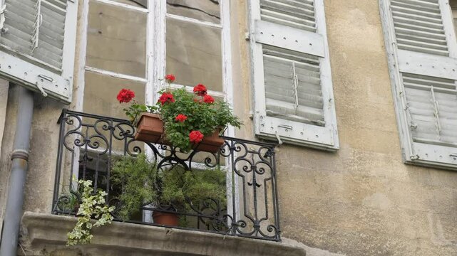 Vibrant flowers adorn a charming window in Aix-en-Provence showcasing the beauty of Place des Trois Ormeaux