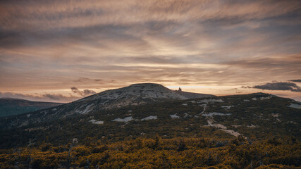 A rugged and rocky hillside with a cloudy sky in the distant background