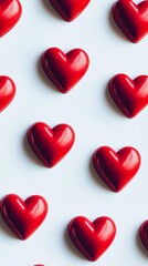 Shiny red hearts are arranged neatly on a white backdrop, creating a visually appealing and romantic pattern perfect for valentine's day or any love-themed project
