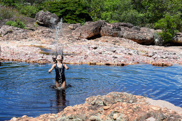 Little girl playing on the river