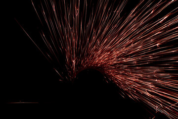 Naklejka premium red sparks from the grinder glowing in the dark