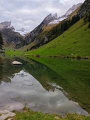 A clear lake in a swiss alp mountain during a cloudy evening in september