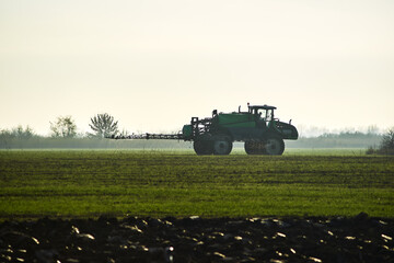 Tractor sprayer in morning fog field agriculture plant treatment powerful agricultural machinery