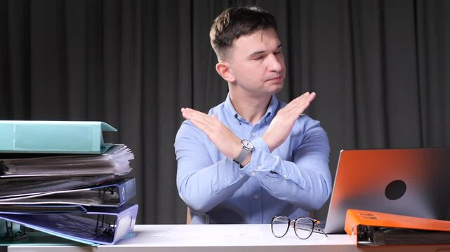 Businessman making stop sign with crossed arms in office