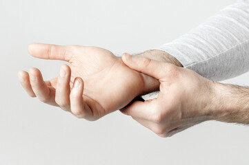 Carpal tunnel syndrome and wrist pain. Man holds to sore spot, panorama, studio shot