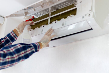 A technician cleaning and maintaining air condition unit..Aircondition service and maintenance,...