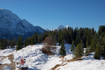 Snowy winter landscape in Mittenwald, Bavaria, showcasing mountains and forests under clear skies