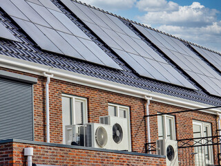 air source heat pump unit installed outdoors at a modern home with solar panels in the Netherlands...