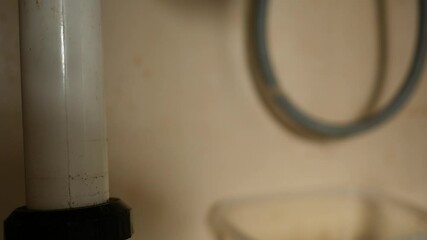  Trap under kitchen sink vanity with leaky hose blurry in background