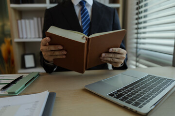 Businessman dressed in a suit is working in an office at a company. A senior executive is in a private office and doing many things. The atmosphere of a private office is calm and peaceful.
