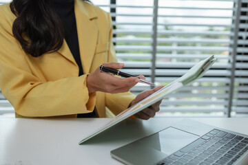 Obraz premium a female executive office working is sitting and working in her private office, a female company owner sits in her company's office, entrepreneur, businesswoman works with a lot of paperwork