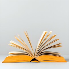 Fototapeta premium Open Book, New Beginnings: A yellow hardcover book lies open, its pages fanned out invitingly. The image evokes a sense of possibility, knowledge, and exploration. A timeless symbol of learning.