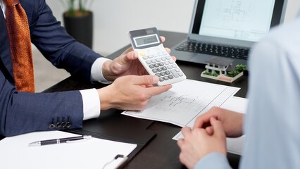 不動産の見積もりを計算するビジネスマン