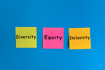 diversity equity inclusion or DEI symbol on sticky notes over blue background