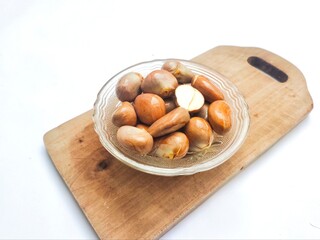 Jackfruit seeds, or Beton in Javanese, on a bowl on a wooden cutting board on white background. The...