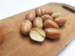 Jackfruit seeds, or Beton in Javanese, on a bowl on a wooden cutting board on white background. The jackfruit seeds can be boiled to be eaten. Jackfruit seeds have many benefits and antioxidants.