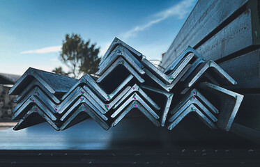 Equal Angles Steel angle iron Metal profile angle in packs at the warehouse of metal products.The arrangement of hot-dip green steel angles on the rack in warehouseMetal profile angle in packs