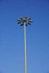 A close up of a modern street lamp against a clear blue sky