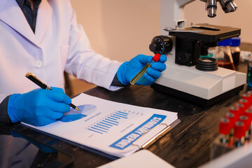 A man works at his desk, reviewing blood lab test results with focus and precision, analyzing data for accuracy and providing critical insights for medical diagnostics and patient health evaluations.