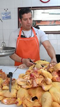 Vertical video of Mexican butcher selling raw chicken