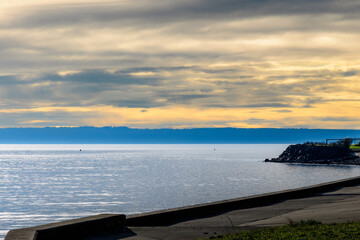2023-12-31 VIEW OF A SALM PUGET SOUND WITH A NICE CLOUDY SKY FROM A BULKHEAD ON WHIDBEY ISLAND...