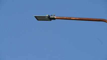 A close up of a modern street lamp against a clear blue sky