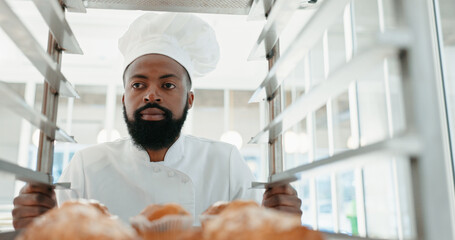Muffin, bakery and cafe with man in kitchen for coffee shop, food industry and breakfast. Shelf, chef and nutritionist with male baker and dessert trolley in restaurant for baking, hotel and order