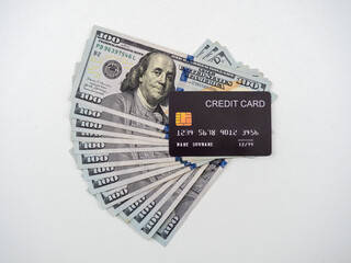 Fake black credit card on many 100 Dollar banknotes cash, isolated on white background. Money fan,...
