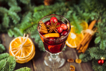 Hot mulled wine in glass on the rustic background with christmas decorations. Selective focus. Shallow depth of field. Christmas mood.