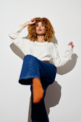 Stylish woman posing in casual outfit with curly hair, showcasing confidence and modern fashion...