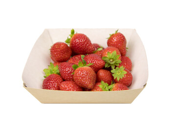 Ripe strawberries from the store, in an open cardboard tray. View from above. The box is highlighted on a white background.